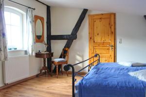 BuchholzZur Alten Tabakscheune的一间卧室设有蓝色的床,铺有木地板。