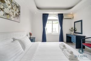 胡志明市La Casona Hotel的卧室配有一张带蓝色窗帘的大型白色床