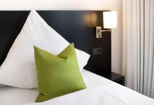StettenKAM Hotel by WMM Hotels的一张白色的床,上面有绿色枕头
