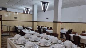 维塞乌Hotel Bela Vista的一间用餐室,配有白色的桌椅、盘子和杯子