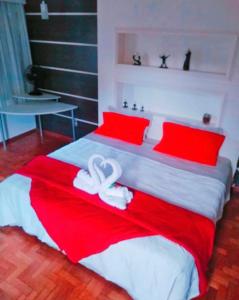 特雷索波利斯Pousada Jupter的一间卧室配有一张带红色和白色床单的大床