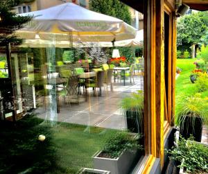 克拉科夫艺术花园住宅酒店的透过窗户可欣赏到带桌椅的庭院景色。