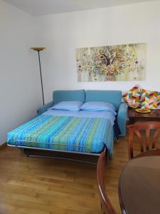 蒙特卡蒂尼泰尔梅Appartamento Clary的一张蓝色的床,位于带桌子的房间