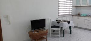 萨尔雷Ka-Bela 2的厨房配有桌子、电视、桌子和椅子