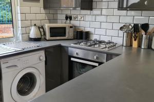 南安普敦Morris Lodge, Southampton - 1 bedroom, Free WIFI & Parking的厨房配有微波炉和洗衣机。
