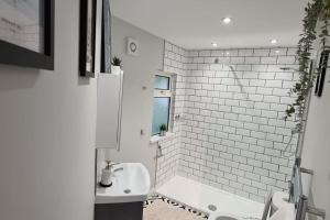 南安普敦Morris Lodge, Southampton - 1 bedroom, Free WIFI & Parking的白色的浴室设有水槽和浴缸。