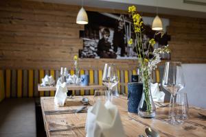蓬高圣约翰Der Alpenblick的餐厅里一张桌子,上面放着眼镜和鲜花