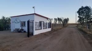 恩塞纳达港Cabañas Los Laureles Ruta del vino bc的土路旁的白色小建筑