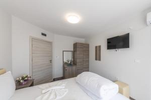 巴尔奇克Мотел "Релакс" Motel "Relax", Балчик,的白色卧室配有白色的床和平面电视