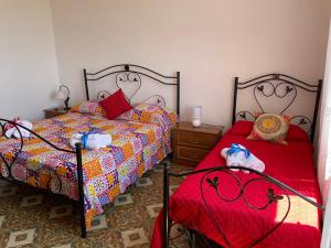特拉帕尼Sunset的一间卧室配有两张单人床和红色床单