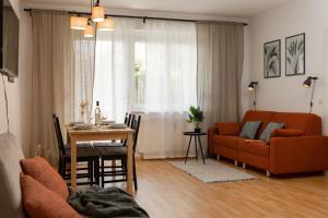 格拉茨Fresh Apartment with Terrace + Free Parking的客厅配有橙色沙发和桌子