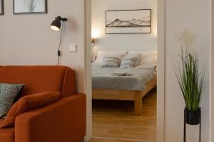 格拉茨Fresh Apartment with Terrace + Free Parking的一间卧室配有床、沙发和灯