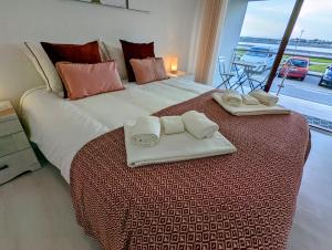 普拉亚达巴拉Silvaapartments的一间卧室配有一张大床和两条毛巾