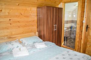莫伊科瓦茨Tara Valley Eco Lounge的一间卧室配有一张木墙床