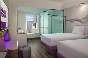 迈阿密YOTEL Miami的酒店客房设有两张床和窗户。