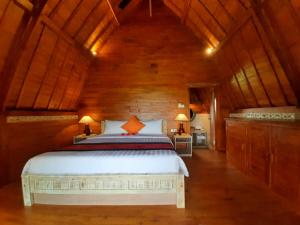 乌布Pondok Gandalangu Ubud-Dikelilingi Hamparan Sawah的一间卧室设有一张床和木制天花板