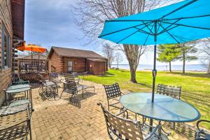 Rapid RiverBeachfront Lake Michigan Log Cabin with Sauna!的露台上的一张带蓝伞的桌子