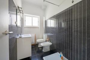 里斯本Sunset Balcony Apartment, By TimeCooler的浴室设有白色卫生间和黑色瓷砖。