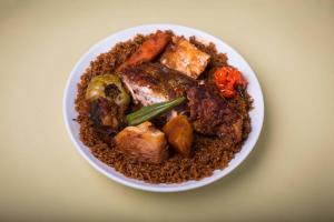 土巴迪亚劳Hotel Mimosa Airport的桌上一碗食物,包括肉类和蔬菜