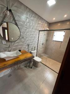 蒂拉登特斯Pouso Primavera的带淋浴、盥洗盆和卫生间的浴室