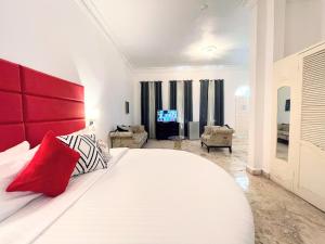 安东尼奥港Jamaica Palace Hotel的一间卧室配有一张白色大床和红色床头板