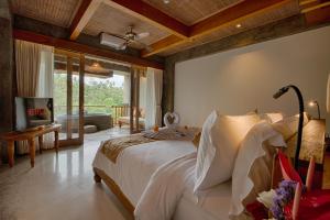 乌布Kastara Resort的一间卧室设有一张床和一间客厅。