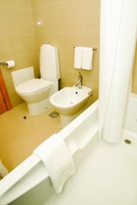 马希库白色水域酒店的浴室配有卫生间、盥洗盆和浴缸。