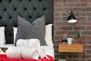 开普敦Urban Artisan Luxury Suites by Totalstay的一间卧室配有一张带枕头和灯的床