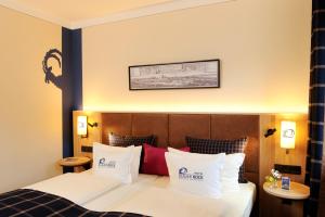 慕尼黑贝拉尔博克酒店的酒店的客房 - 带白色和红色枕头的床