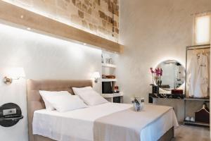 罗德镇Chateau Anax Boutique Hotel的卧室配有白色的床和镜子