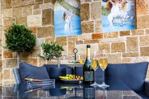罗德镇Chateau Anax Boutique Hotel的一张桌子,上面放着两杯葡萄酒和一碗水果