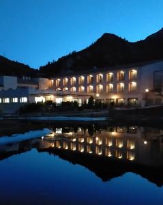 VandellósLa Figuerola Hotel & Restaurant的一座晚上在水中点亮的建筑
