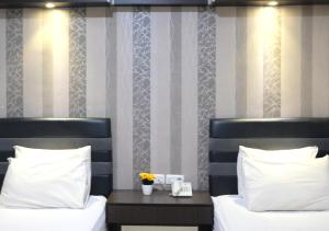 西冷Grand Krakatau Hotel Serang的一间卧室配有两张床和一张鲜花桌
