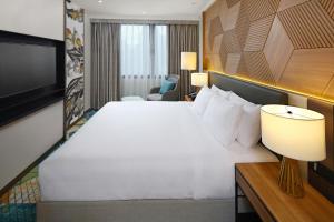 宿务Holiday Inn Cebu City, an IHG Hotel的酒店客房设有一张大床和一台电视。