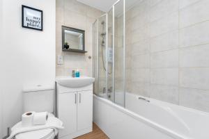 利文斯顿Cheerful Stays - Livingston - 4 Bedroom 3 Bath home的一间带水槽、淋浴和卫生间的浴室