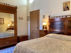 蒙特里久尼Monteriggioni Castello的一间卧室设有两张床和大镜子