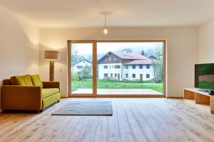 巴特科尔格鲁布Alpinlife Ferienhaus的带沙发和大窗户的空客厅
