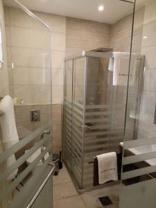 安曼AlQimah Hotel Apartments的带淋浴和玻璃淋浴间的浴室