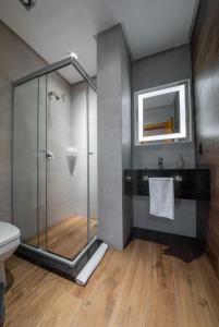 格拉玛多Hotel Boutique Britanico的一间带玻璃淋浴和卫生间的浴室