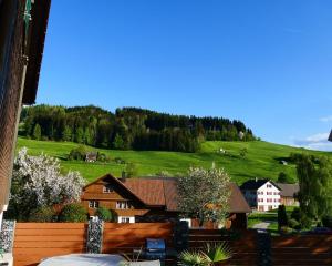 GähwilFerienwohnung Eisenring in idyllischer Umgebung的享有山丘背景房屋的景致