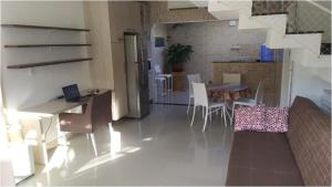 伯迪亚哥Casa na Praia de Maitínga - Bertioga - SP的客厅设有厨房、桌子和椅子