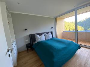 多恩比恩Wohnung Staufenblick und Wohnung Firstblick的一间卧室设有蓝色的床和大窗户
