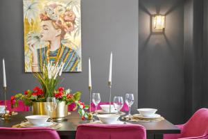 惠特比The Most Central and Lux Whitby House - Hot-Tub的一张带粉红色椅子和绘画的餐桌