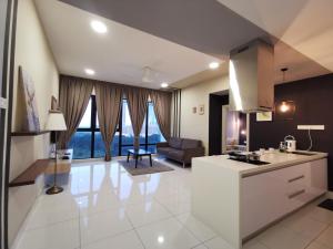 新山Mid Valley Southkey Mosaic Cozy Suite at Johor Bahru的厨房以及带沙发和桌子的客厅。