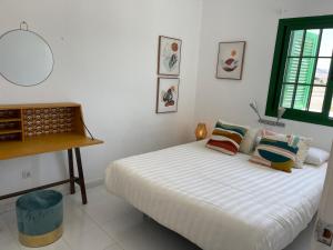 科蒂略Cotillo Lagoons Apartment的白色卧室配有床和书桌