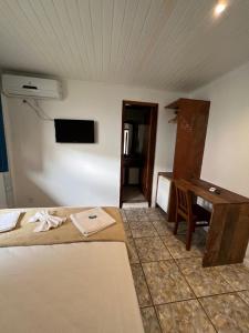 布希奥斯Tortuguita Ossos - Suítes的客房设有一张床、一张桌子和一张桌子。
