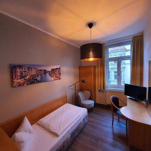 格赖茨Hotel Friedensbruecke的一间卧室配有一张床、一张桌子和一张桌子