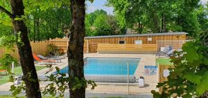 Tour-en-SologneENTRE LOIRE ET CHER Gîte "Le Nid Douillet"的一座游泳池,位于一座带建筑物的庭院内