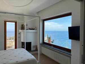 伊斯基亚Agapanto Luxury Accommodation的卧室设有海景大窗户