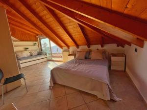 莫内利亚Appartamento Moneglia的一间带一张床的卧室,位于带木制天花板的房间内